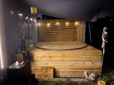 an outdoor sauna is lit up at night with fairy lights on the top and bottom