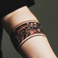 a woman's arm with a tattoo on the wrist and flower designs on it