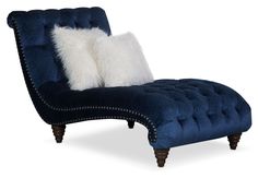 a blue chaise lounge chair with white pillows