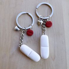 two pill shaped keychains are sitting on a table