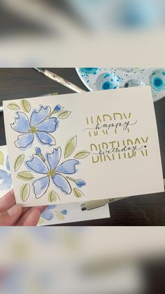 someone holding up a birthday card with flowers on it