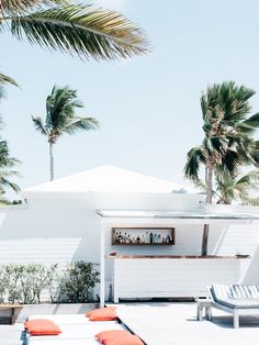 an outdoor bar with lounge chairs and palm trees