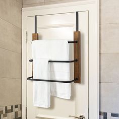 a towel rack with two towels hanging from it's sides in front of a bathroom door