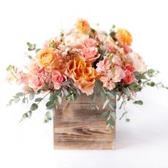 an arrangement of flowers in a wooden box on a white background with space for text