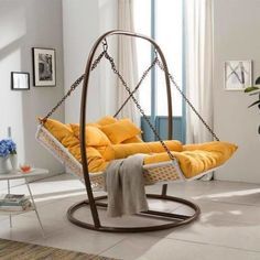 a swing bed with yellow pillows in a living room