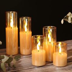 several candles are lit on a wooden table