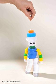 a hand is reaching for a toy that looks like a snowman