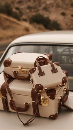 three pieces of luggage sitting on top of a car