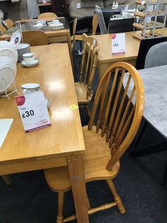 wooden chairs and tables in a store with price tags on the back of each chair