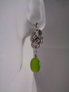 These earrings are hand woven one ring at a time into a double cloud cover weave. Made using high quality saw cut bright aluminum jump rings to ensure smooth closures.  And, finished with green cat's eye glass beads and hypoallergenic stainless steel earring posts.  These earrings  will not tarnish and are ultra light-weight to wear. They can be easily cleaned with liquid soap and water and polished with a dry cloth.  The earrings measure approximately 1 3/4 inches (4.5 cm) from the top of the e Chainmaille Patterns, Chain Mail Earrings, Diy Earrings Dangle, Chainmaille Jewelry Patterns, Chain Maille Patterns, Chainmail Earrings, Chainmail Patterns, Chainmaille Earrings, Jump Ring Jewelry