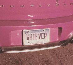 a license plate on the back of a pink car