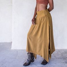 The IDIS Abby Skirt in Tumeric is a Mid rise skirt with high side splits and smocking in the back creating an elasticised waiste band for extra comfort.Made from a medium weight woven Rayon.Part of the Graceful Rebellion Range.SIZE GUIDE XS: bust 76-82 cm | waist 64-70 cm | hips 78-84 cmS: bust 82-84 cm | waist 70-76 cm | hips 84-90 cmM: bust 84-88 cm | waist 76-82 cm | hips 90-96 cmL: bust 94-100 cm | waist 82-88 cm | hips 96-102 cmXL: bust 100-106 cm | waist 88-104 cm | hips 102-108 cmDELIVERY Asymmetrical Relaxed Maxi Skirt With Side Slits, Bohemian Pleated Midi Skirt, Asymmetrical Skirt With Side Slits For Spring, Flowy Pleated Skirt With High-low Hem, Spring Asymmetrical Skirt With Side Slits, Relaxed Fit High-low Hem Lined Skirt, Bohemian Asymmetrical Pleated Maxi Skirt, Asymmetrical Skirt With Side Slits For Summer, Summer Asymmetrical Maxi Skirt With Side Slits