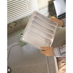 a person holding a dish rack in their hand