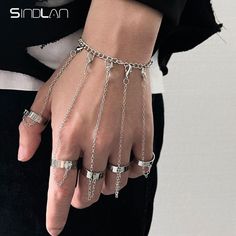 a person wearing chains and rings on their hands, with the word sinlan written in silver