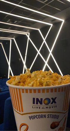 a bucket of popcorn sitting on top of a table