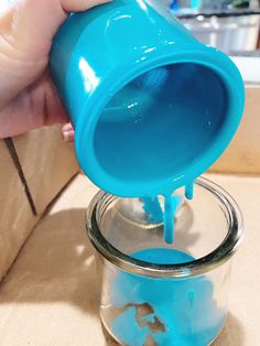 a person pouring blue liquid into a jar