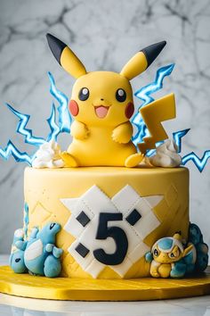 A Pokémon themed birthday cake with Pikachu Pikachu Cake Birthdays, Pokémon Birthday Party, Pokemon Birthday Party Ideas, Birthday Pikachu, Pokémon Cake, Pokemon Themed Party, Pokemon Birthday Cake, Pokémon Birthday, Pikachu Cake