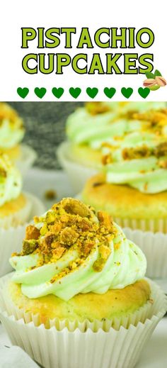 some cupcakes with white frosting and pistachio on top