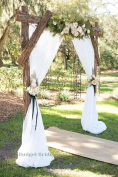 the wedding arch is decorated with flowers and fabric for an outdoor ceremony at the park