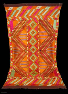 an orange and pink pillow with geometric designs on it