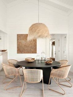 a dining room table with chairs and a painting on the wall