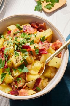 a bowl filled with potatoes, bacon and parsley