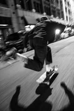 a man riding a skateboard down the side of a street