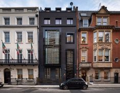 a black car is parked in front of several buildings on the side of the street