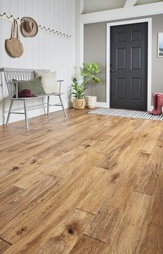 a living room with wood flooring and white walls, including a black front door