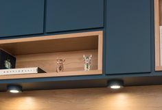 two small figurines are on the shelf above the kitchen sink and under the cabinets