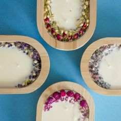 four wooden trays filled with different types of candles