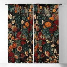 the curtain is open to show an image of flowers and leaves on black background with oranges, yellows, and browns