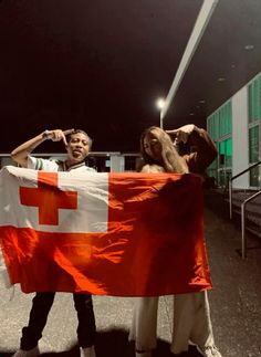 two people holding a large flag in the street