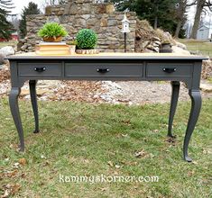 an old desk with two drawers and some plants on top