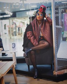 a woman is sitting in a chair with her legs crossed and wearing tights, stockings and boots