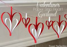 red and white paper hearts are hanging on a clothes line with the words valentine's day behind them