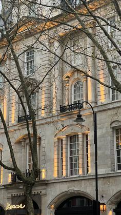 an old building is lit up by the light of the street lamps in front of it