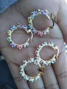 three pairs of hoop earrings are shown in the palm