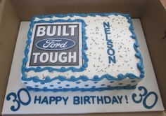 a birthday cake in a box with the words built ford tough on it and an image of a truck