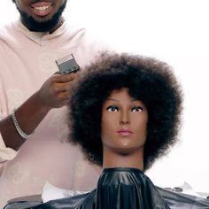 a man cutting another mans hair with an electric clipper on top of his head