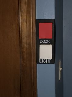 the door is open and there are two different colors on the light switch box in front of it