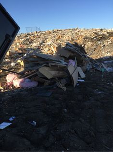 a pile of trash sitting on top of a dirt field