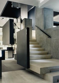 the interior of a modern house with concrete stairs