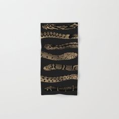 a black and gold scarf with snake skin on it, hanging from the wall in front of a white background