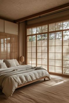 a large bed sitting in a bedroom next to two windows