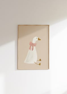 a white duck with a pink bow on it's head hanging from a wall