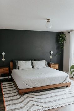 a bedroom with a bed, rug and two lamps on either side of the bed