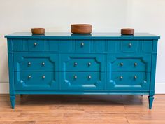 a blue dresser with two bowls on top