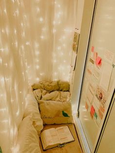 an unmade bed in the corner of a room with white lights on the walls