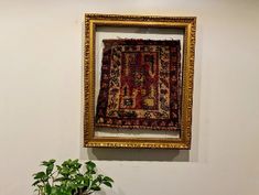 a potted plant sitting in front of a painting on the wall